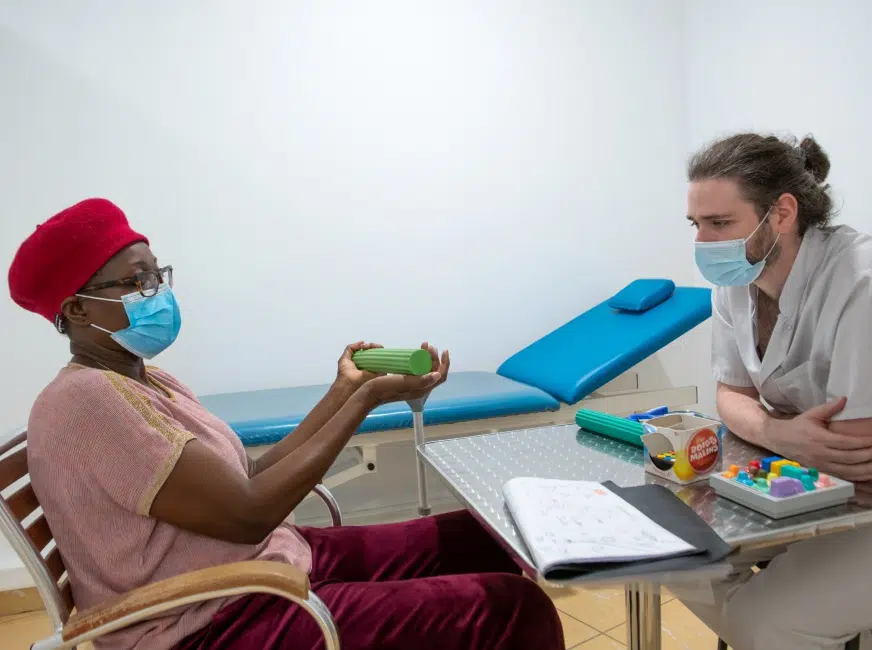 Femme assise tenant un objet vert - Des professionnels éxpert | Clinalliance Paris