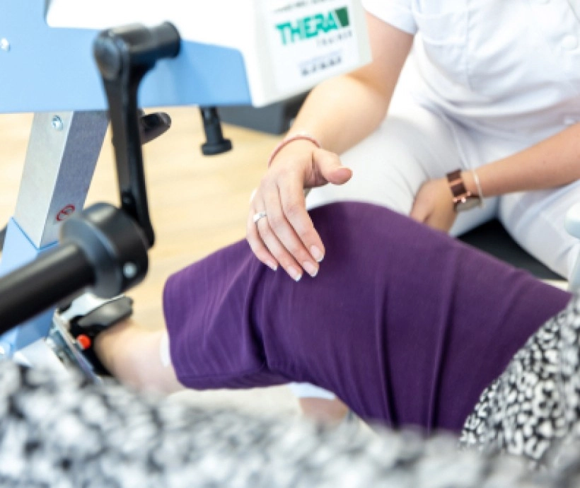 Femme en rééducation utilisant un appareil spécialisé pour son genou | Clinalliance Paris