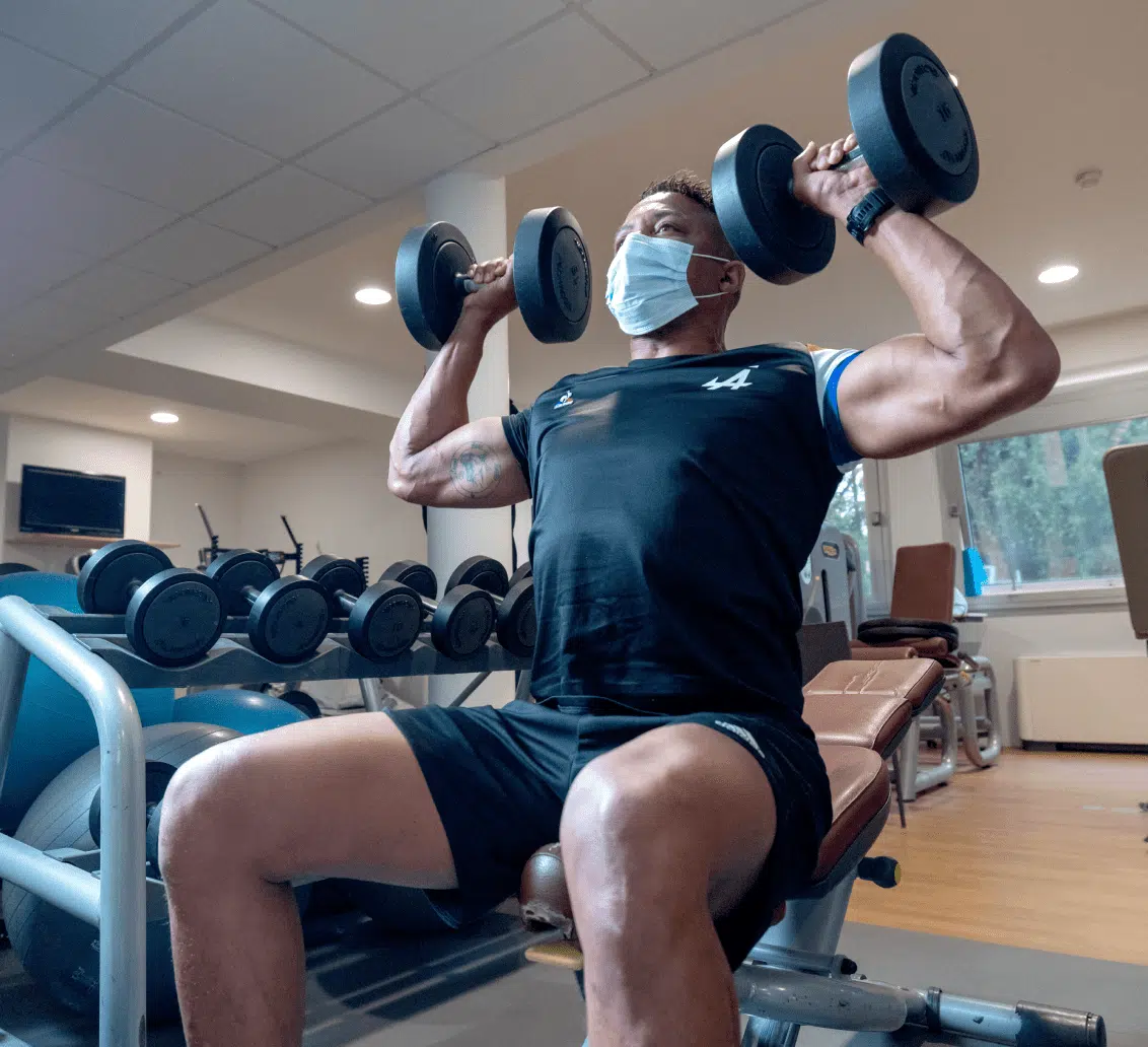 Homme faisant des exercices avec deux haltères- reathletisation | Clinalliancve Villiers-Sur-Orge
