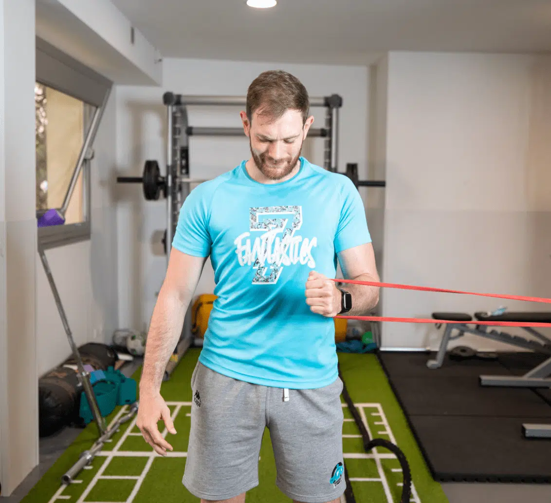 Homme dans une salle de sport, utilisant des bandes de résistance pour s'entraîner - réedcuation | Clinalliance villiers-sur-orge