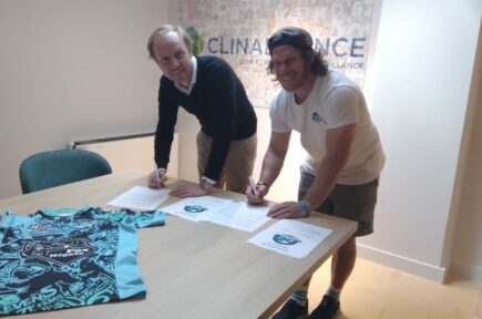 Deux personnes en train de signer des documents sur une table avec un maillot de sport | Clinalliance Paris