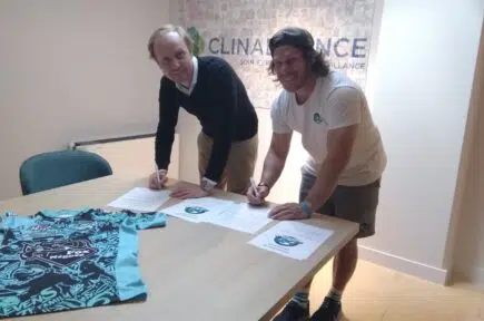 Deux personnes en train de signer des documents sur une table avec un maillot de sport | Clinalliance Paris