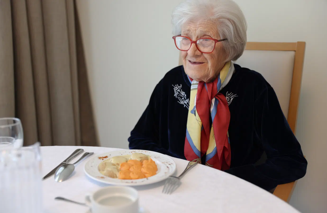 Femme agée assise à une table de repas avec un plat - restauration | Clinalliance voisins-le-bretonneux
