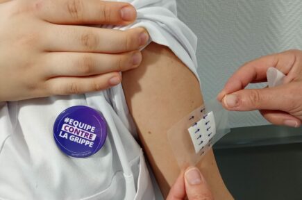 Homme reçevant un patch sur le bras, portant un badge | Clinalliance Paris