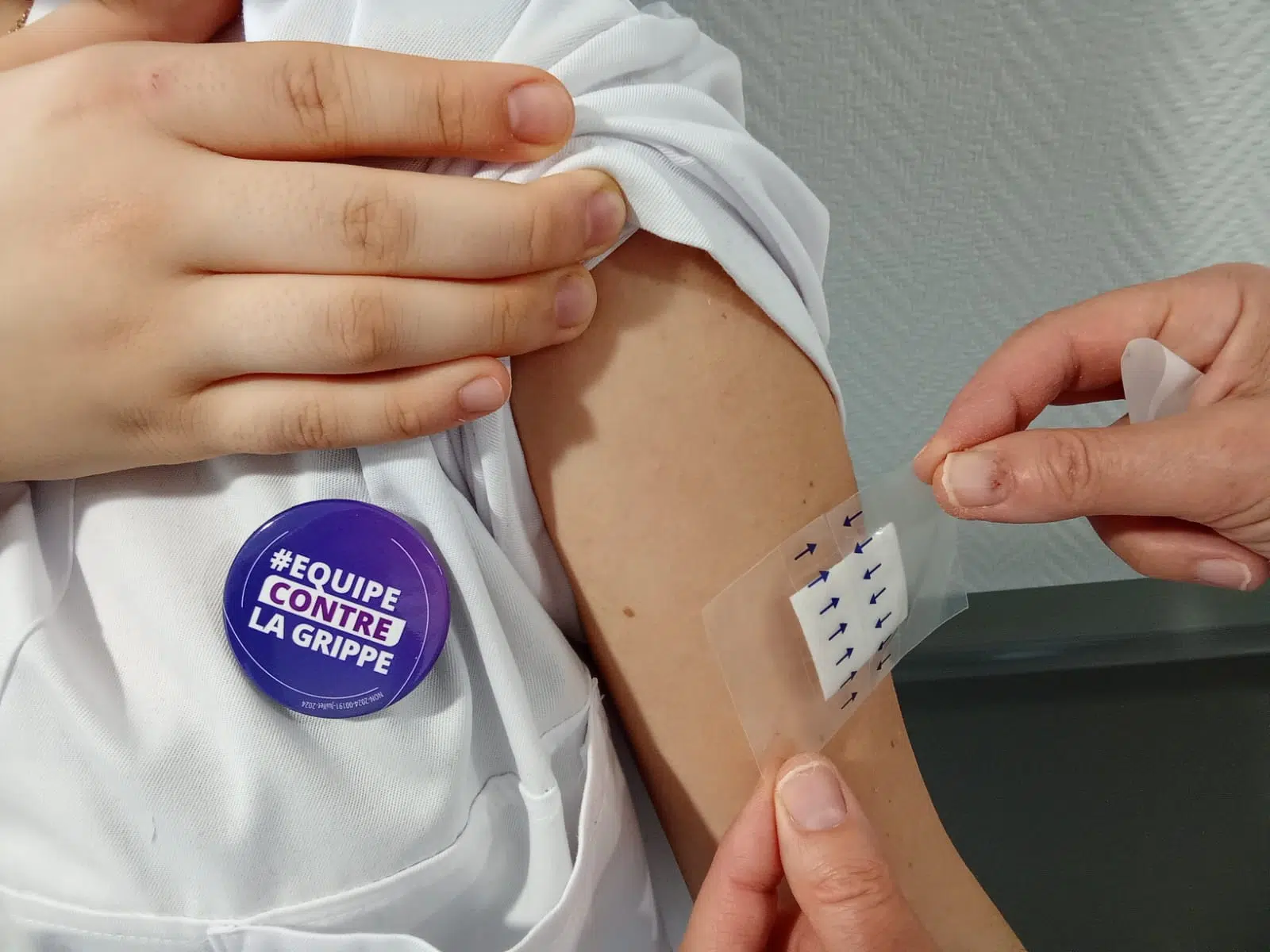 Homme reçevant un patch sur le bras, portant un badge | Clinalliance Paris