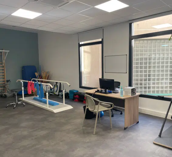 Salle de rééducation avec équipements de physiothérapie et un bureau - Votre prise en charge pluridisciplinaire | Clinalliance Paris