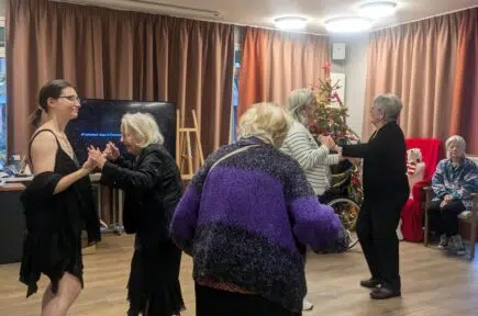 Groupe de personnes agées dansant dans une salle avec un sapin de Noël | Clinalliance | Maurepas